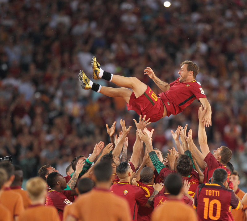 Totti kvaddur af liðsfélögum sínum.