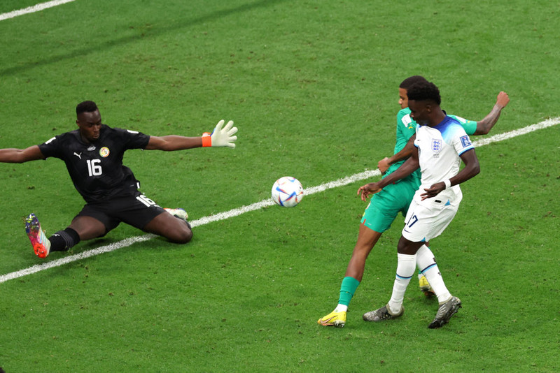 Bukayo Saka kemur boltanum framhjá Mendy í markinu