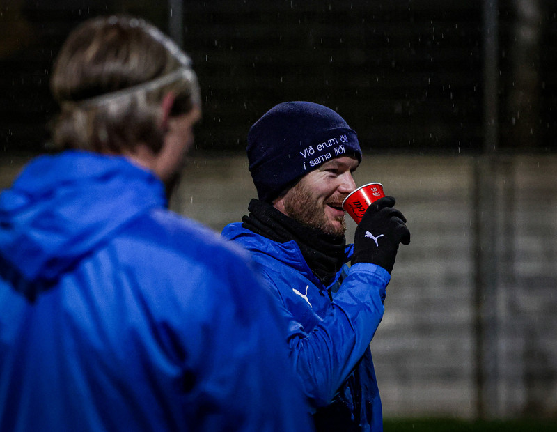 Aron Einar Gunnarsson drekkur úr Coke glasi á æfingu Íslands.